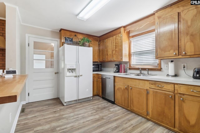 kitchen with white refrigerator with ice dispenser, light wood-style flooring, stainless steel dishwasher, black microwave, and a sink