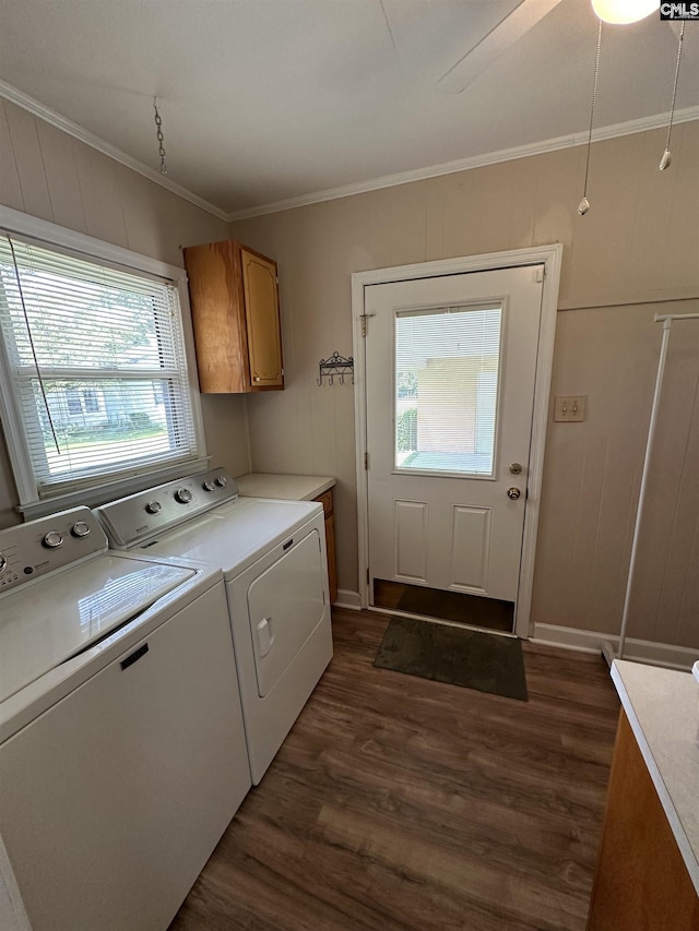 laundry area featuring dark wood-type flooring, cabinet space, crown molding, and separate washer and dryer