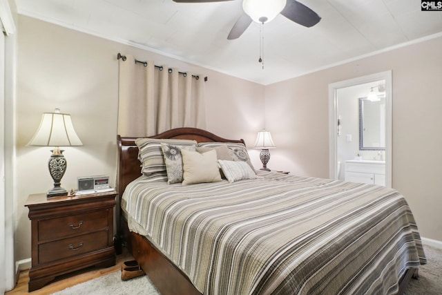 bedroom featuring a ceiling fan, baseboards, crown molding, and ensuite bath