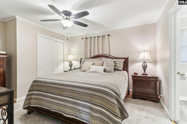 bedroom with light carpet, crown molding, a ceiling fan, and baseboards