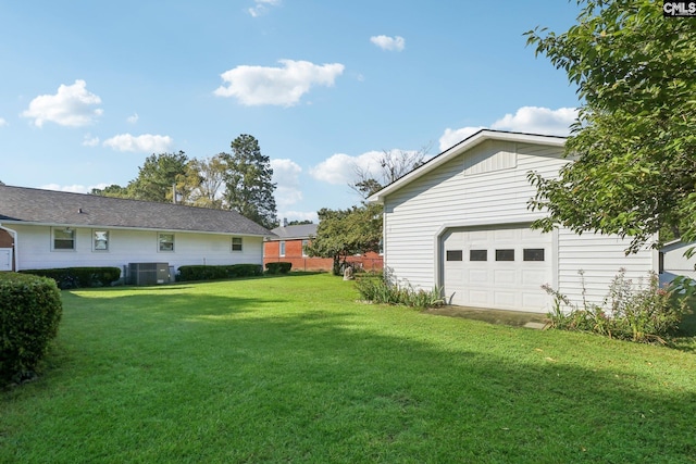 view of yard with a garage and central air condition unit