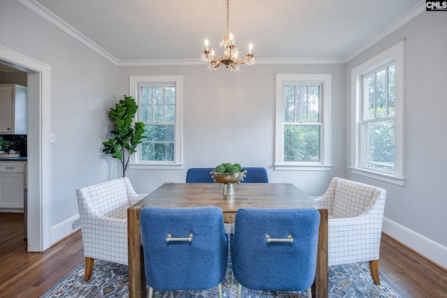 dining room featuring dark hardwood / wood-style floors, a chandelier, and ornamental molding