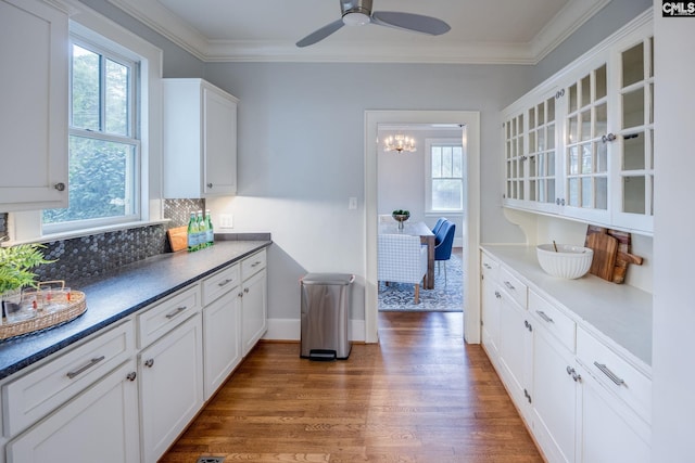 kitchen with ornamental molding, dark hardwood / wood-style flooring, ceiling fan, and white cabinetry