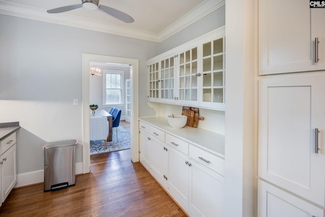 kitchen featuring white cabinets, dark hardwood / wood-style floors, crown molding, and ceiling fan