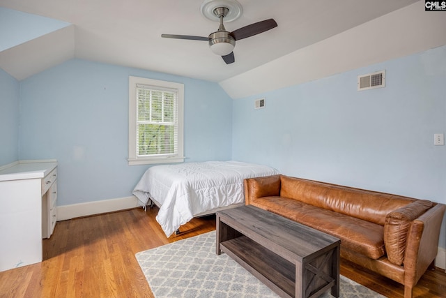 bedroom with ceiling fan, lofted ceiling, and light hardwood / wood-style floors