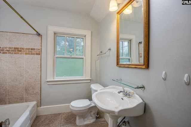 full bathroom with toilet, vaulted ceiling, tiled shower / bath, sink, and tile patterned flooring