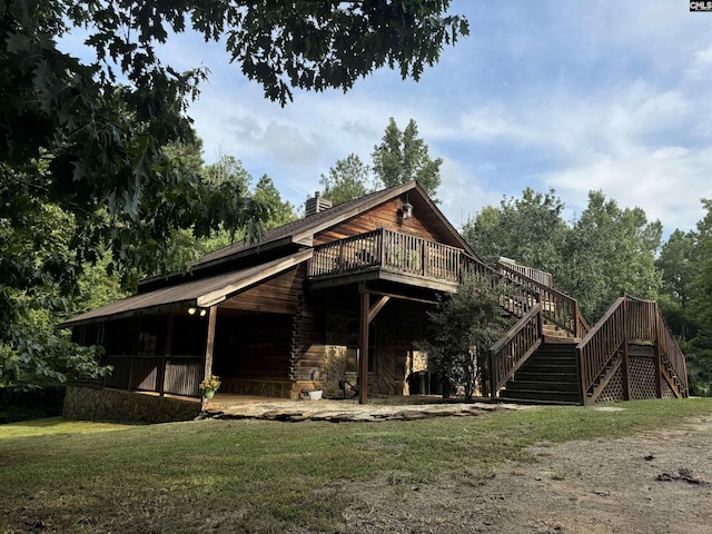 rear view of property featuring a wooden deck and a yard