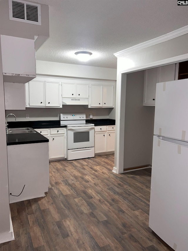 kitchen featuring under cabinet range hood, a sink, dark countertops, white appliances, and white cabinets