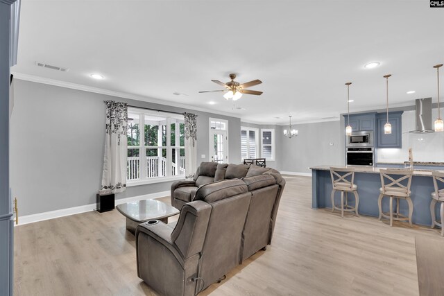 living room featuring sink, ceiling fan with notable chandelier, ornamental molding, and light hardwood / wood-style floors