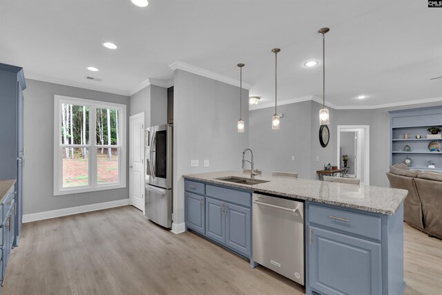 kitchen featuring pendant lighting, light stone countertops, light hardwood / wood-style floors, stainless steel appliances, and sink