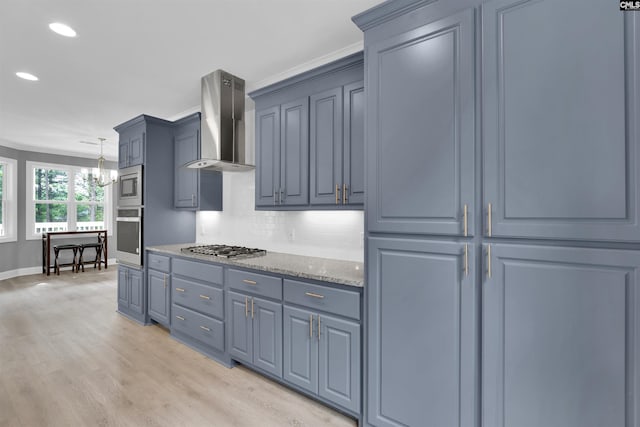 kitchen featuring stainless steel appliances, pendant lighting, decorative backsplash, light hardwood / wood-style flooring, and wall chimney range hood