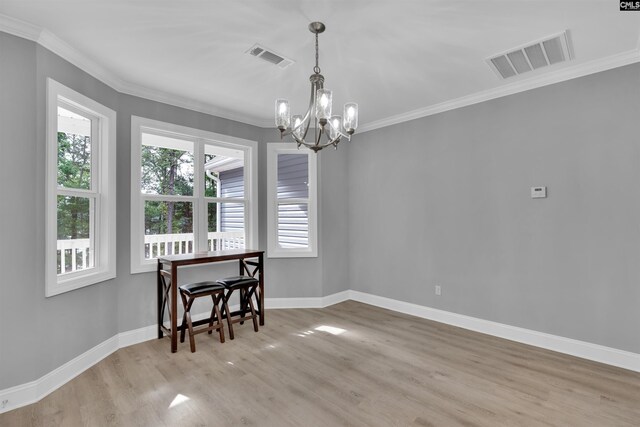 dining space with light hardwood / wood-style flooring, a chandelier, plenty of natural light, and ornamental molding