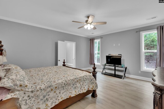 bedroom featuring ceiling fan, light wood-type flooring, multiple windows, and crown molding