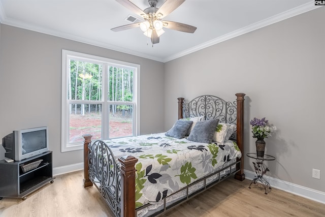 bedroom featuring ceiling fan, light wood-type flooring, ornamental molding, and multiple windows