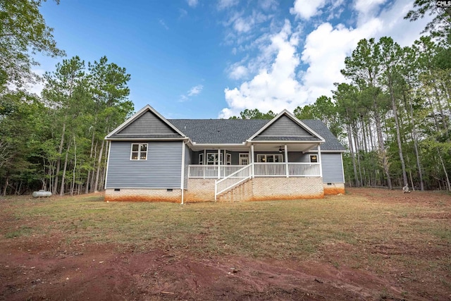 back of house featuring covered porch and a lawn