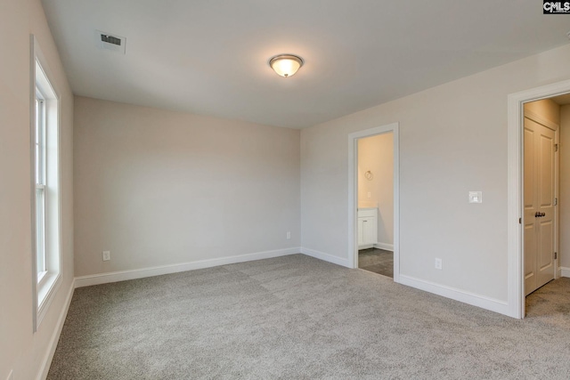 unfurnished bedroom featuring carpet and ensuite bathroom