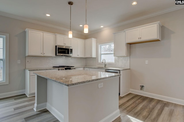 kitchen with decorative backsplash, white cabinetry, appliances with stainless steel finishes, and light hardwood / wood-style floors