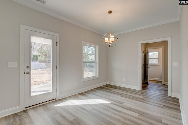 interior space with light wood-type flooring, crown molding, and an inviting chandelier