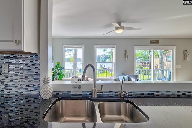 kitchen featuring ceiling fan, sink, tasteful backsplash, and plenty of natural light