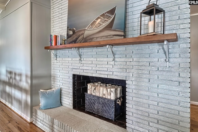 room details featuring hardwood / wood-style flooring and a brick fireplace