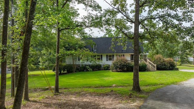 cape cod house featuring a front yard