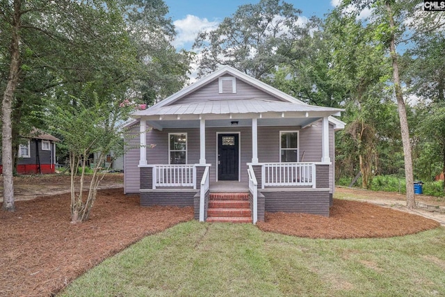 bungalow-style home featuring covered porch and a front yard