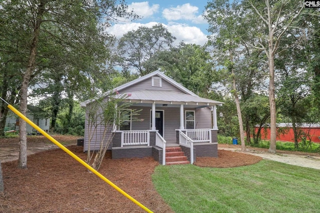 bungalow-style house featuring a porch, a front lawn, and a playground