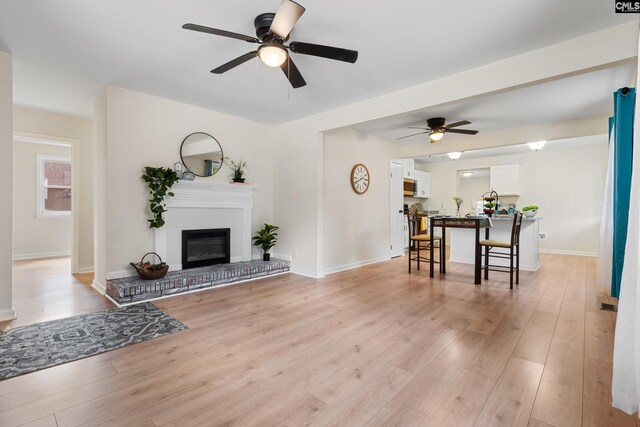 living room featuring light wood-type flooring and ceiling fan