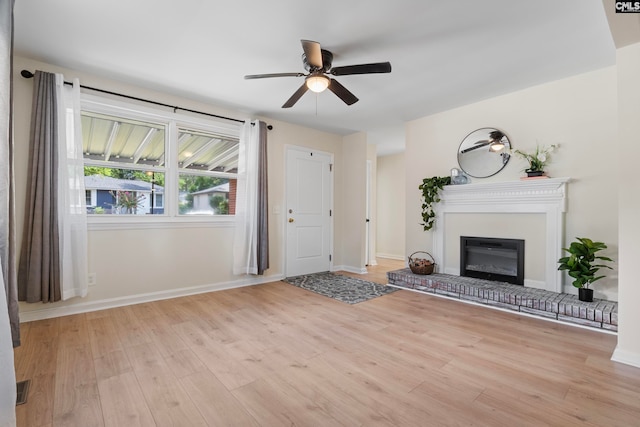 unfurnished living room with ceiling fan, light hardwood / wood-style flooring, and a brick fireplace