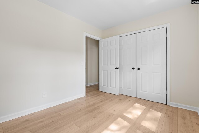 unfurnished bedroom featuring a closet and light hardwood / wood-style flooring