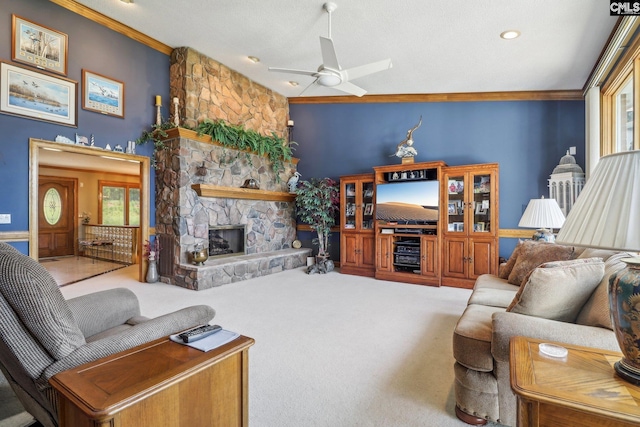 carpeted living room with a fireplace, a ceiling fan, and crown molding