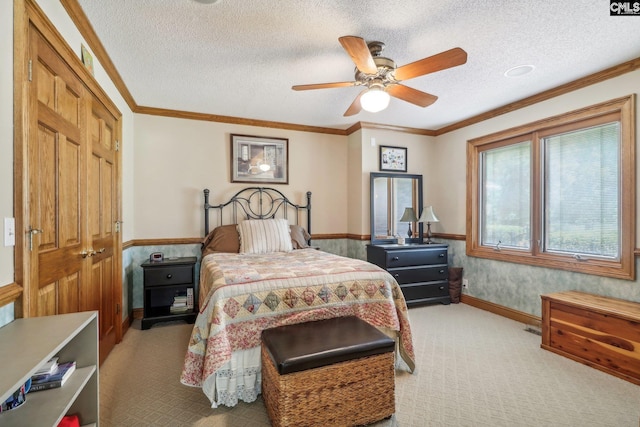 bedroom featuring light carpet, ceiling fan, a textured ceiling, and crown molding