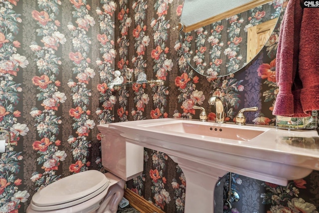 half bathroom with toilet and wallpapered walls