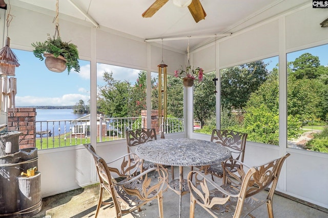 sunroom with a water view and ceiling fan