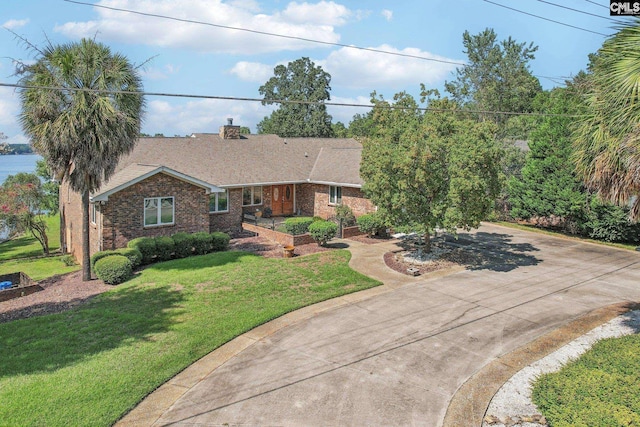 view of front of property with driveway, a front lawn, and brick siding