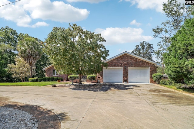 view of front of property featuring a garage, driveway, and brick siding