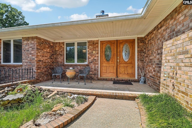 doorway to property with brick siding