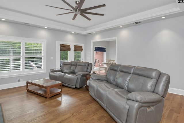 living area with recessed lighting, wood finished floors, ceiling fan, visible vents, and a raised ceiling