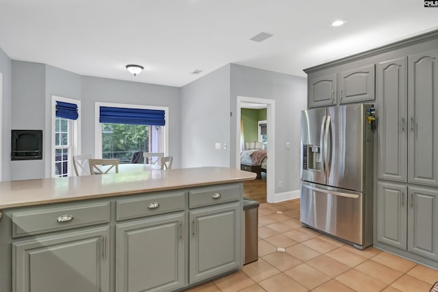 kitchen featuring stainless steel refrigerator with ice dispenser, gray cabinetry, and light countertops