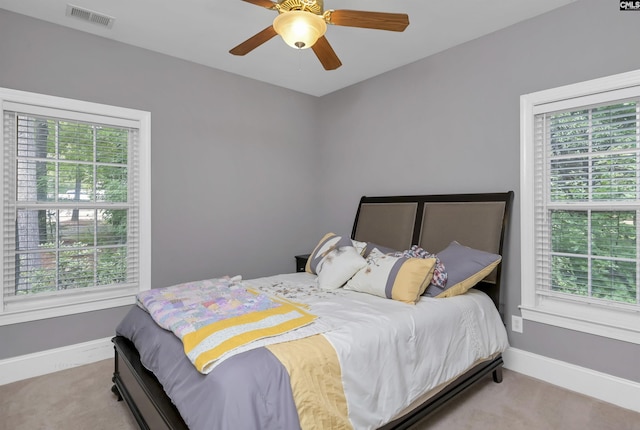 bedroom with baseboards, visible vents, carpet floors, and multiple windows