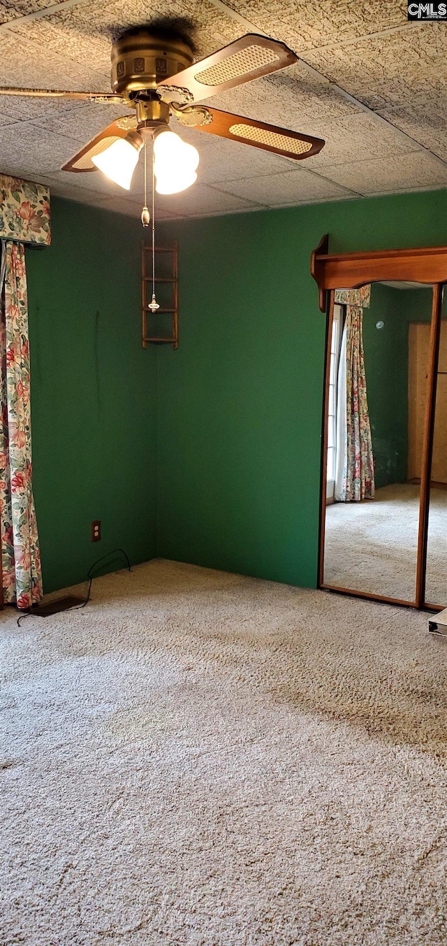 carpeted empty room featuring ceiling fan