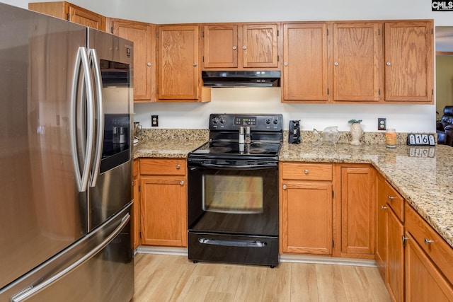 kitchen with light wood finished floors, smart refrigerator, light stone countertops, under cabinet range hood, and black / electric stove