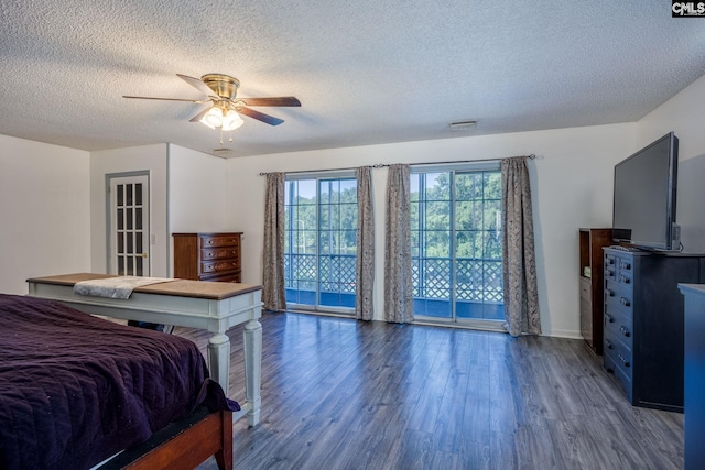 bedroom featuring a ceiling fan, access to exterior, a textured ceiling, and wood finished floors