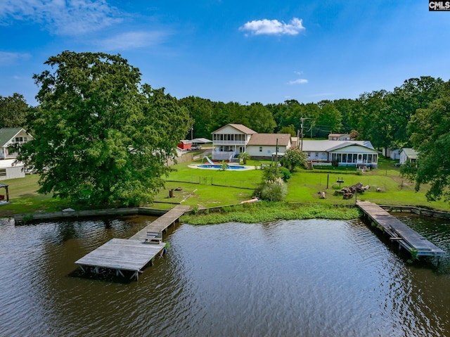 view of dock with a water view, fence, and a yard