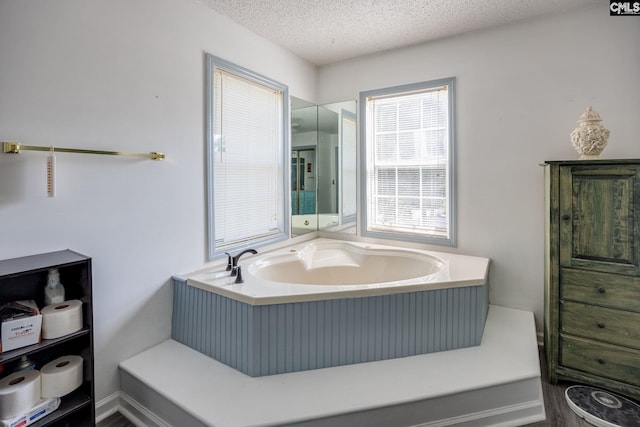 bathroom featuring a garden tub and a textured ceiling