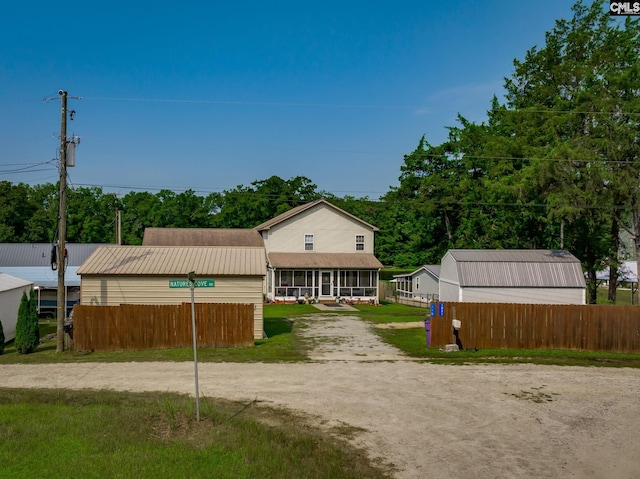 view of front of home with driveway and fence