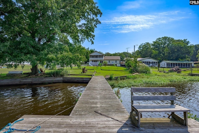 dock area featuring a lawn and a water view