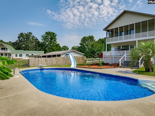 view of swimming pool featuring a fenced in pool, a water slide, fence, and stairway