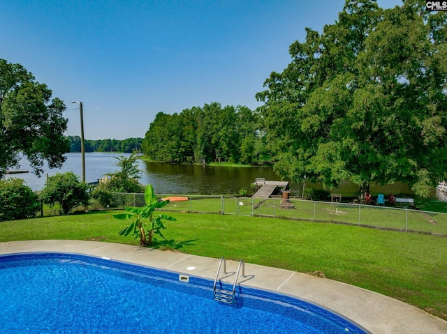 pool with a water view, fence, and a yard