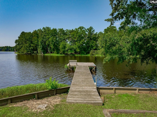 dock area featuring a forest view and a water view